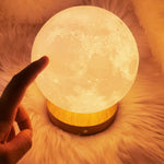 Hand touching the moon lamp to change the light