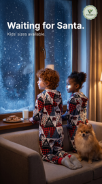 Kids in matching Christmas print onesies looking out at the snow